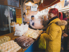 Crowded Namdaemun Market alley with steam rising from food stalls