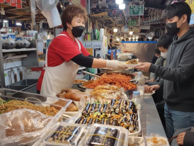 Vendor at Gwangjang Market selling Mayak gimbap and other foods