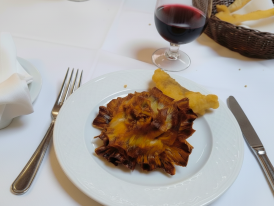 Fried artichokes alla giudia opened like bronze flowers on white plate