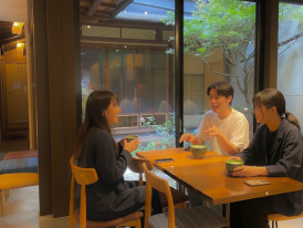 Cozy machiya café with wooden beams and locals sipping coffee in a quiet corner