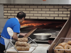 Fresh bagels coming out of wood-fired oven at night