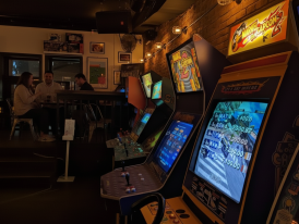 Vintage arcade game machines lit up in retro bar setting