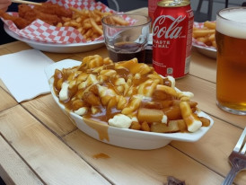 Steaming poutine with crispy fries, melting cheese curds, and rich brown gravy