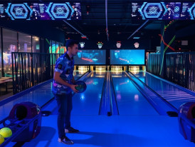 Cosmic bowling neon-lit lanes with families at Singapore entertainment area