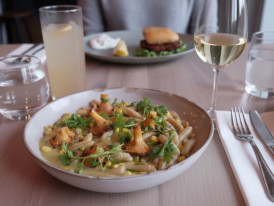 A plate of vegan gnocchi from The Acorn, rich, creamy, and topped with fresh herbs