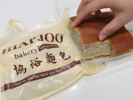 Traditional banana cake slice on plate at Hiap Joo Bakery shopfront