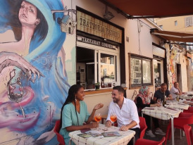 Outdoor trattoria and murals in Via del Pigneto with locals 