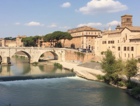 The ancient stone bridge arch reflected in the Tiber River water