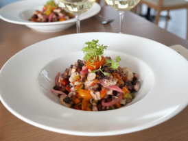 Octopus salad with parsley and olive oil on a white plate