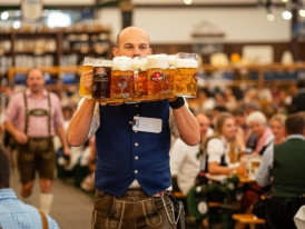 Dinner bill and coins on a wooden beer hall table in Munich