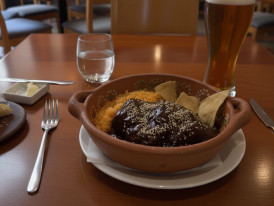 Traditional mole poblano in clay bowl with sesame seeds