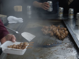 A busy horumon grill shop in Nishinari with skewers sizzling on the grill