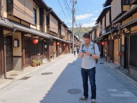 Traveler checking phone on a quiet Kyoto side street