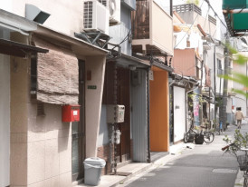 Quiet residential street in Osaka with narrow lanes and small buildings