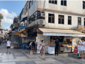 Street food and snack stalls near Cheung Chau beach, with locals and visitors browsing in a pedestrian street