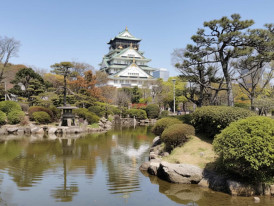 Osaka Castle reflected in a pond within the surrounding park