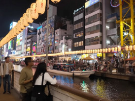 Dotonbori canal in Osaka at night with neon signs, lanterns, and crowds