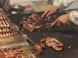 Ikayaki grilled squid being prepared on a hot plate at a Tokyo street food stall