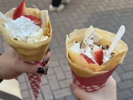 Harajuku-style Japanese crepes filled with whipped cream and strawberries, held while walking in Tokyo