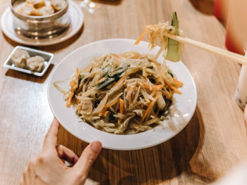 Bowl of Soba noodles and someone using chopsticks Bowl of Soba noodles and someone using chopsticks