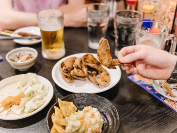 Various Japanese dishes and a hand holding a piece of a Various Japanese dishes and a hand holding a piece of a