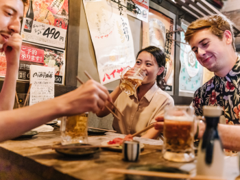 Group having drinks and Japanese food Group having drinks and Japanese food
