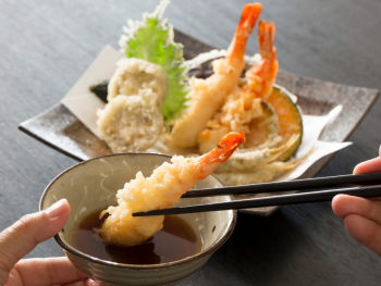Tempura prawns been eaten with chopsticks Tempura prawns been eaten with chopsticks