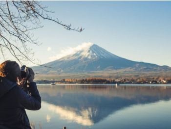 Tourist taking a photo of Mount Fuji from Lake Ashi, Ja