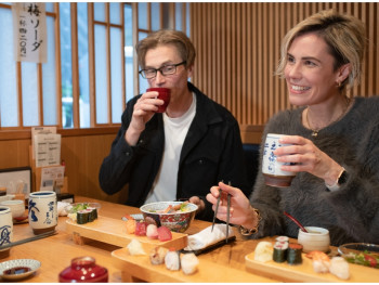 Travelers enjoying sushi in Tokyo, Japan Travelers enjoying sushi in Tokyo, Japan