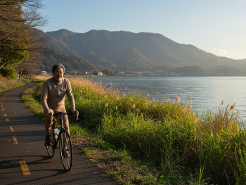 Cyclist on a path along Lake Biwa with reeds and water in the background Cyclist on a path along Lake Biwa with reeds and water in the background