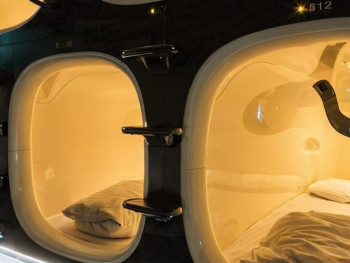 Modern capsule hotel interior showing individual sleeping pods with privacy screens. Image by Shutterstock Modern capsule hotel interior showing individual sleeping pods with privacy screens. Image by Shutterstock