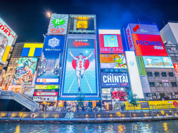 The iconic Glico Running Man sign in Namba with crowds of people below The iconic Glico Running Man sign in Namba with crowds of people below
