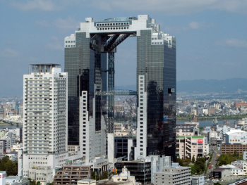 The distinctive twin towers of Umeda Sky Building connected by a sky bridge against blue sky. The distinctive twin towers of Umeda Sky Building connected by a sky bridge against blue sky.