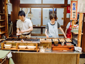 Takoyaki being cooked in street food stall Takoyaki being cooked in street food stall
