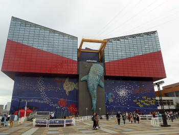 The distinctive cylindrical architecture of Osaka Aquarium with Osaka Bay in the background.photo by Tokumeigakarinoaoshima on Creative Commons Attribution-Share Alike 4.0