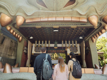 Visitors participating in traditional rituals at Namba Yasaka Shrine with the lion head structure in the background. Visitors participating in traditional rituals at Namba Yasaka Shrine with the lion head structure in the background.