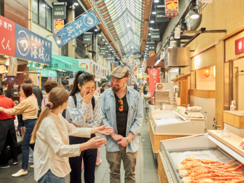 Bustling morning scene at Kuromon Market with fresh seafood displays and local shoppers Bustling morning scene at Kuromon Market with fresh seafood displays and local shoppers