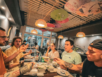 Diverse group of travelers of different ages and backgrounds enjoying food together at a lively Osaka restaurant, representing the universal appeal of the city Photo by Ambroise NICOLAO on Unsplash Diverse group of travelers of different ages and backgrounds enjoying food together at a lively Osaka restaurant, representing the universal appeal of the city Photo by Ambroise NICOLAO on Unsplash