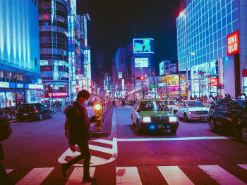 Osaka cityscape at dusk with neon signs beginning to light up and trains visible in the foreground. Image by Masashi Wakui from Pixabay