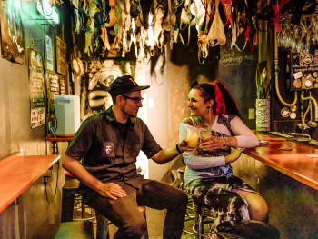 Guest alone with guide at quiet bar in conversation Guest alone with guide at quiet bar in conversation