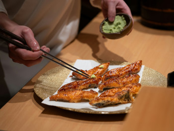 A farewell dinner scene at a small Osaka restaurant with the chef preparing final dishes Photo by Harrison Chang on Unsplash