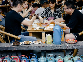 Locals sharing a meal at plastic tables Photo by billow926 on Unsplash