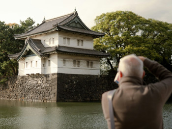 A guest taking a thoughtful photograph of traditional architecture details while their host provides historical context in the background. Image by Ryunosuke Kikuno on Unsplash. A guest taking a thoughtful photograph of traditional architecture details while their host provides historical context in the background. Image by Ryunosuke Kikuno on Unsplash.