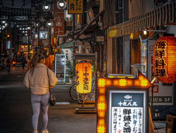 Female traveler walking confidently through well-lit Osaka streets at night with friendly locals nearby Photo by masahiro miyagi on Unsplash Female traveler walking confidently through well-lit Osaka streets at night with friendly locals nearby Photo by masahiro miyagi on Unsplash