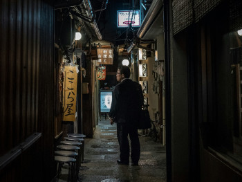 Guest stepping into a narrow, lantern-lit alleyway in Osaka's vintage district Photo by Guillaume Gouin on Unsplash