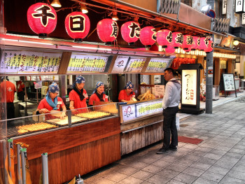 Friendly food vendor chatting with repeat customers at their stall, showing personal relationships