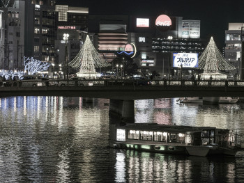 The main winter illuminations at Osaka Hikari Renaissance reflected in the river, with couples and families viewing the display Photo by Nichika Sakurai on Unsplash