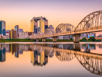 Sunrise over Osaka cityscape with traditional buildings in foreground and modern skyline in background Sunrise over Osaka cityscape with traditional buildings in foreground and modern skyline in background