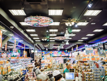 A host guiding travelers through a local shopping district A host guiding travelers through a local shopping district