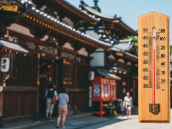 Traditional temperature display showing summer heat levels with historic Kyoto architecture in background. Traditional temperature display showing summer heat levels with historic Kyoto architecture in background.